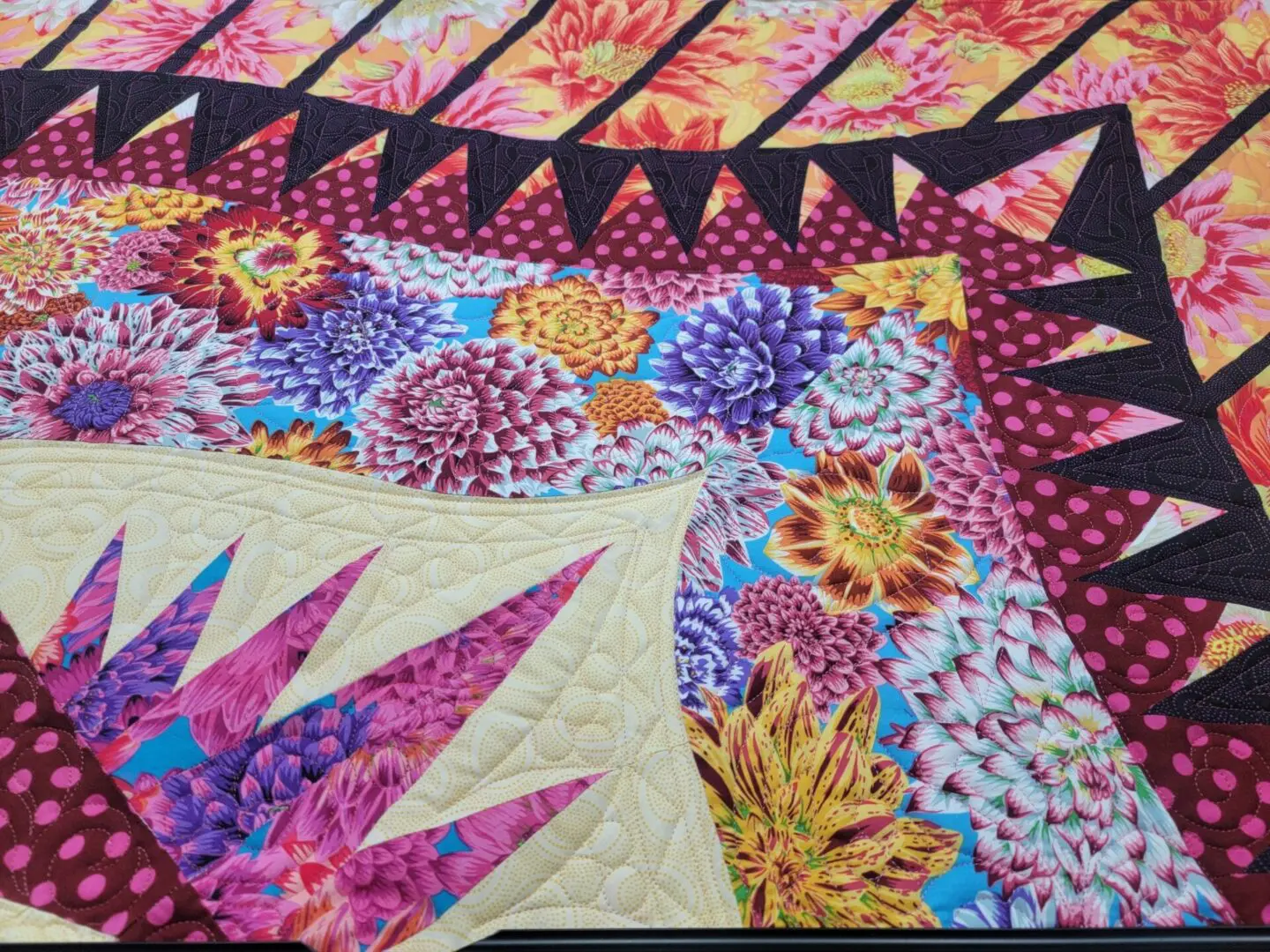 A close up of the quilt with purple and yellow designs