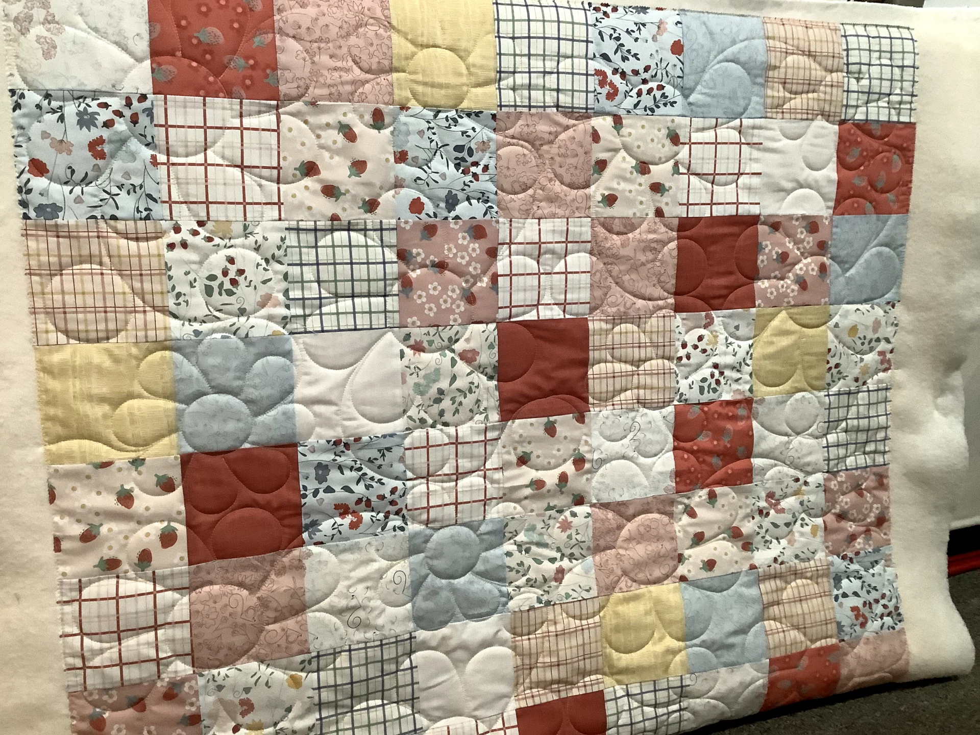 A quilt with different colored squares and circles.