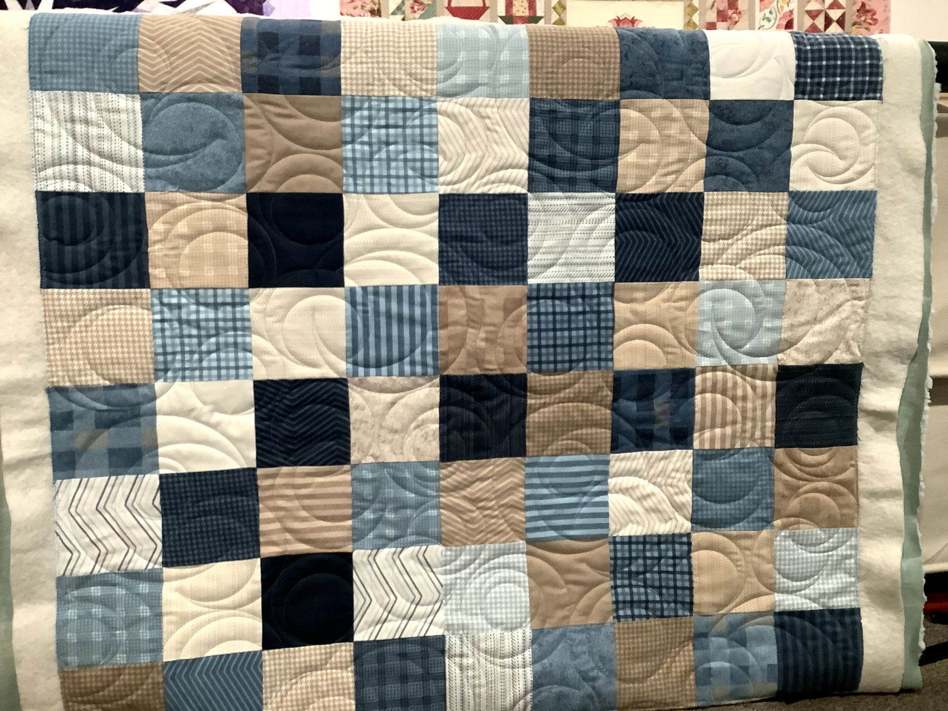 A quilt with squares of different colors and sizes.