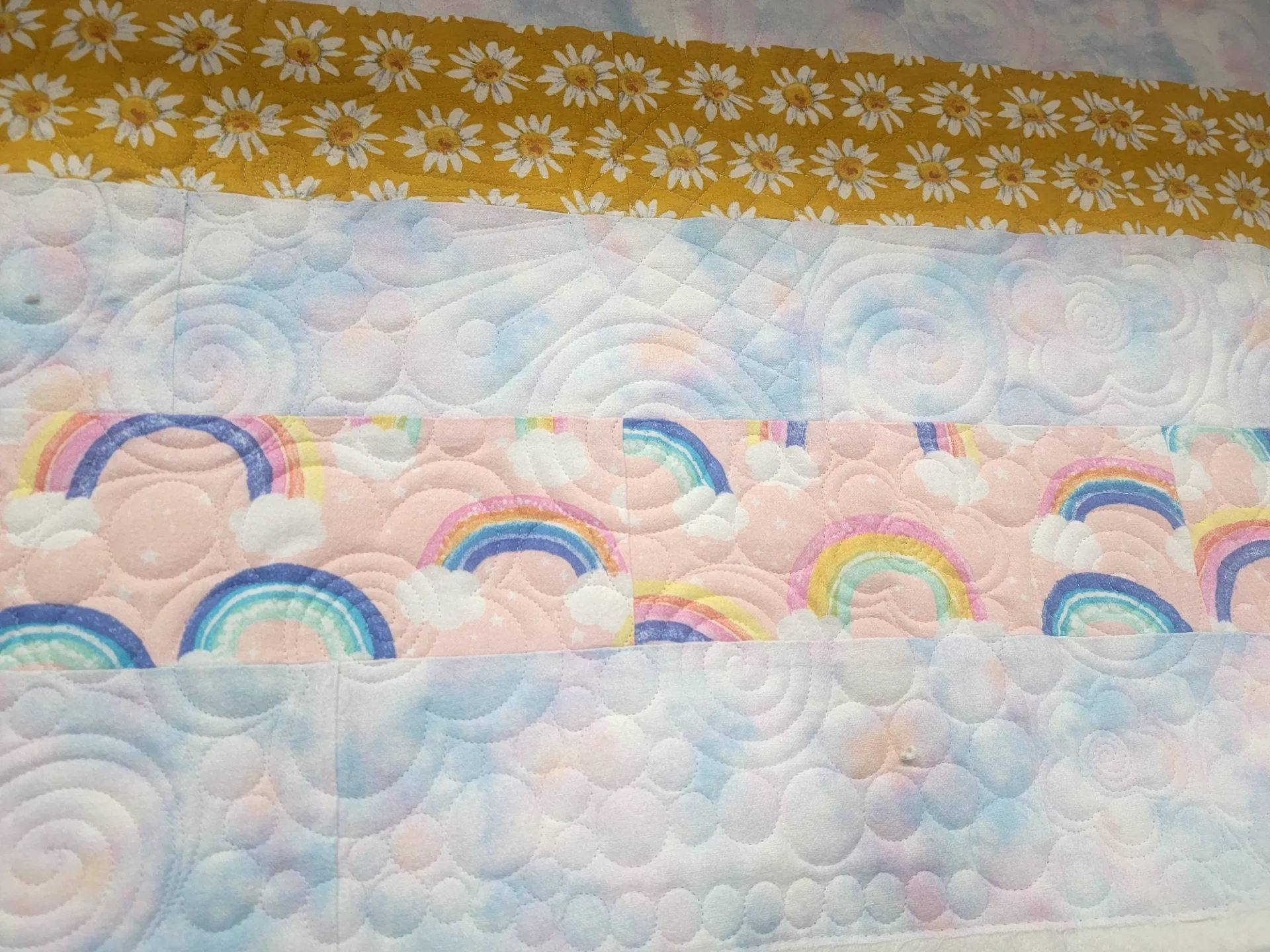 A close up of the rainbow quilt