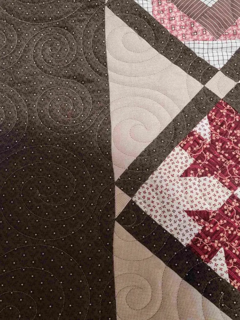 A close up of the quilt with red and white stars.