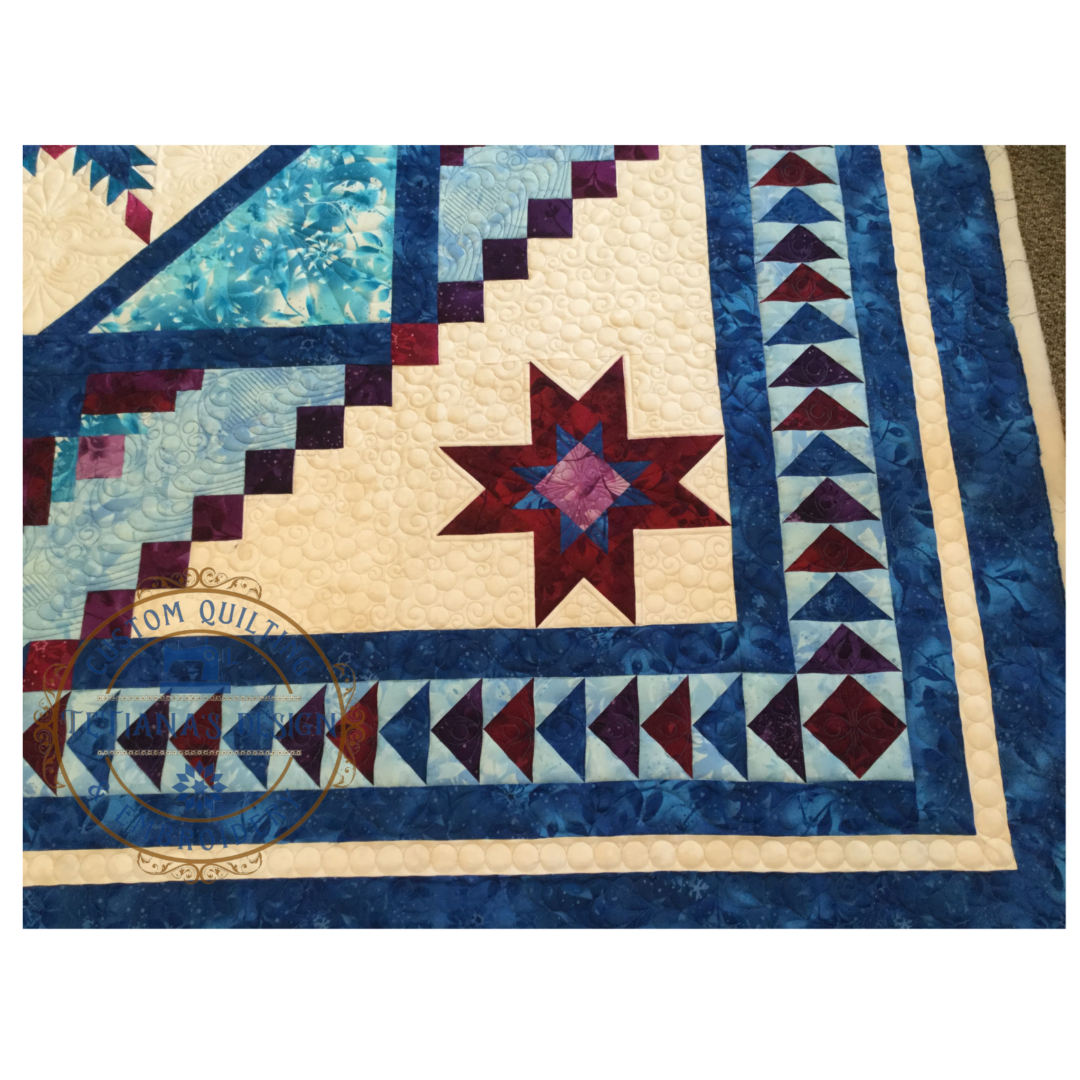 A close up of the quilt with blue and red designs