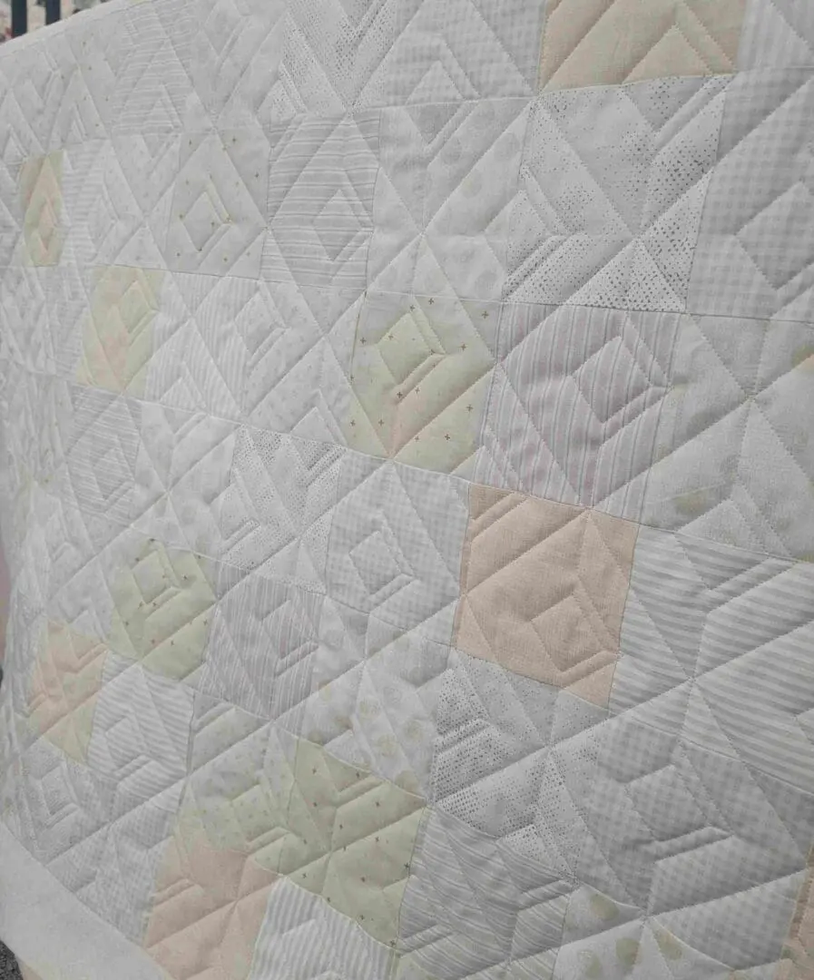 A close up of the quilted fabric on a bed.