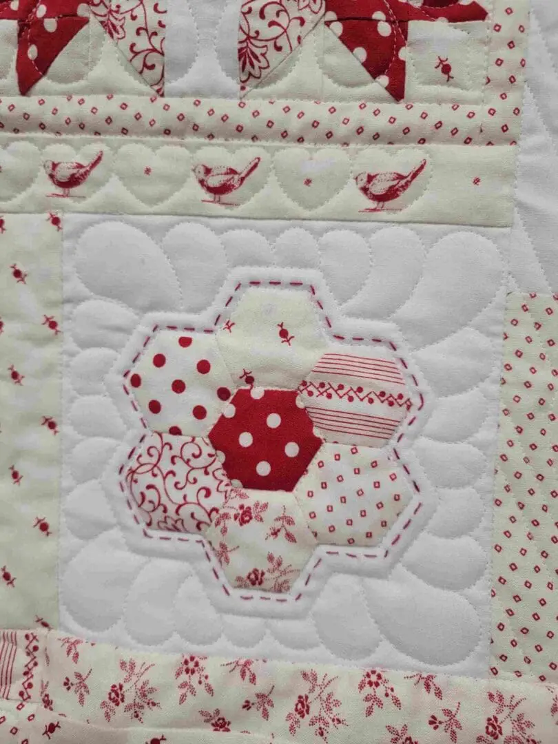 A close up of the red and white quilt