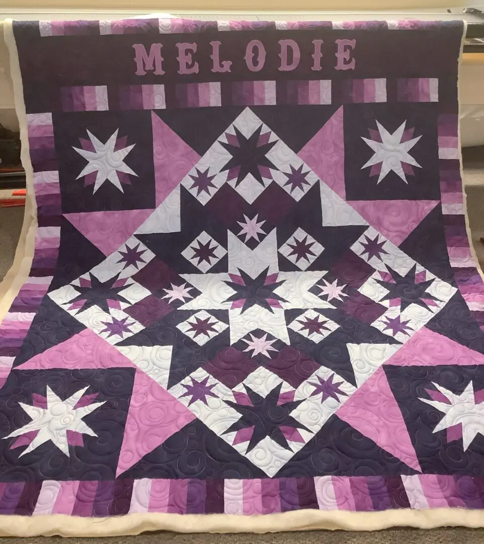 A quilt with the name melodie on it.