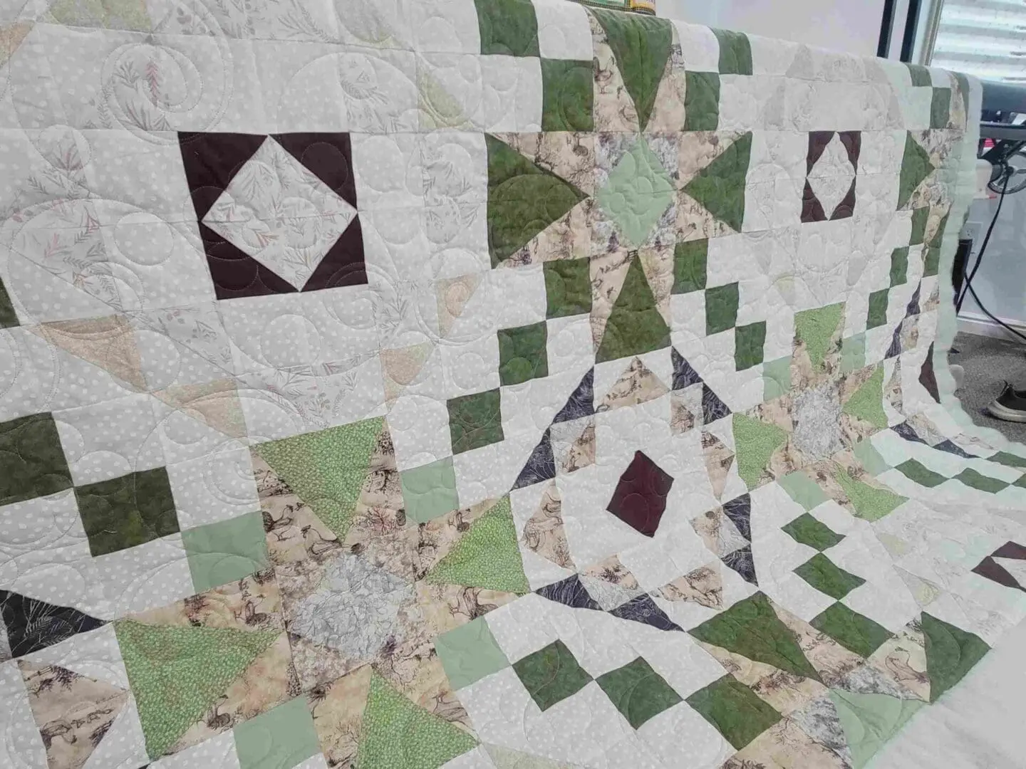 A quilt with different colors of green and brown.