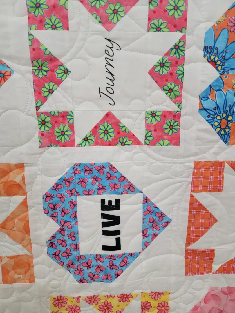 A close up of the words " journey " on a quilt