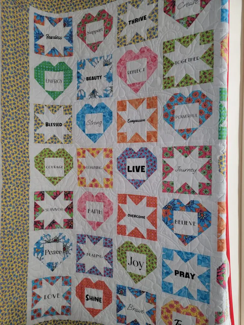 A quilt with words on it is displayed.