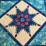 A blue and white quilt with a star design.